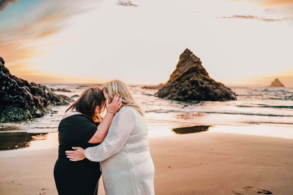 Two brides embrace each other at Sunset on the Oregon Coast