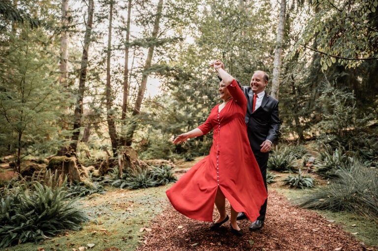 A man twirls his wife in the forest as they celebrate their anniversary with a photo session